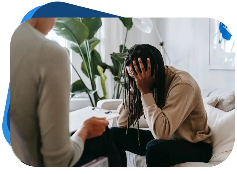 A person sitting down with their head in his hands.